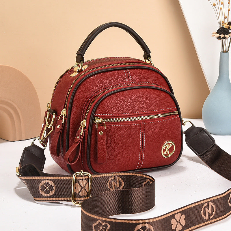 stylish cream and brown crossbody handbag with gold accents and a patterned adjustable strap