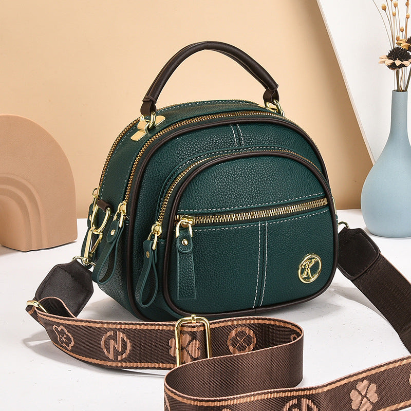 stylish cream and brown crossbody handbag with gold accents and a patterned adjustable strap